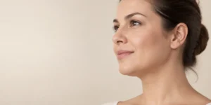 Perfil de uma mulher adulta com a região abaixo do queixo e o contorno do pescoço visíveis, em fotografia clínica natural.